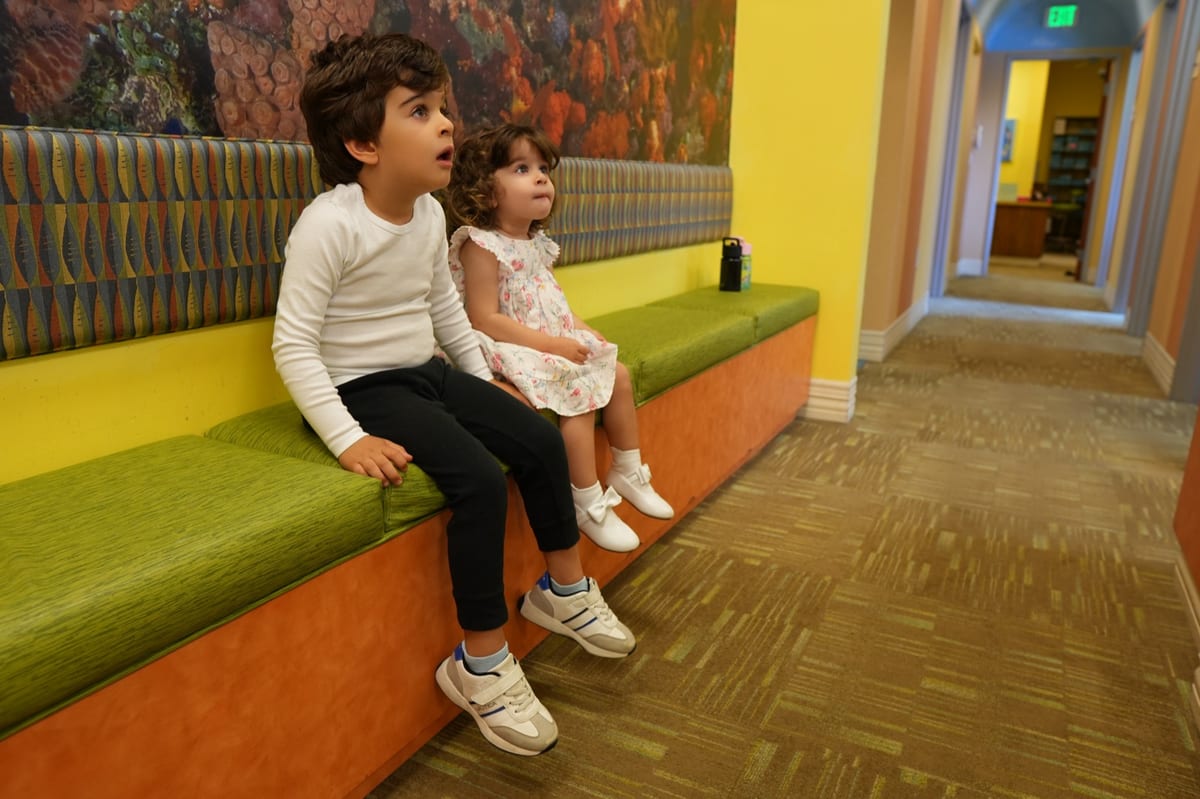 Happy kids in the ocean-themed waiting area at Discovery Children's Dentistry in Carlsbad